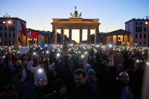 Hunderte Demonstranten bilden mit Smartphones und Feuerzeugen ein Lichtermeer. Foto: Annette Riedl/dpa