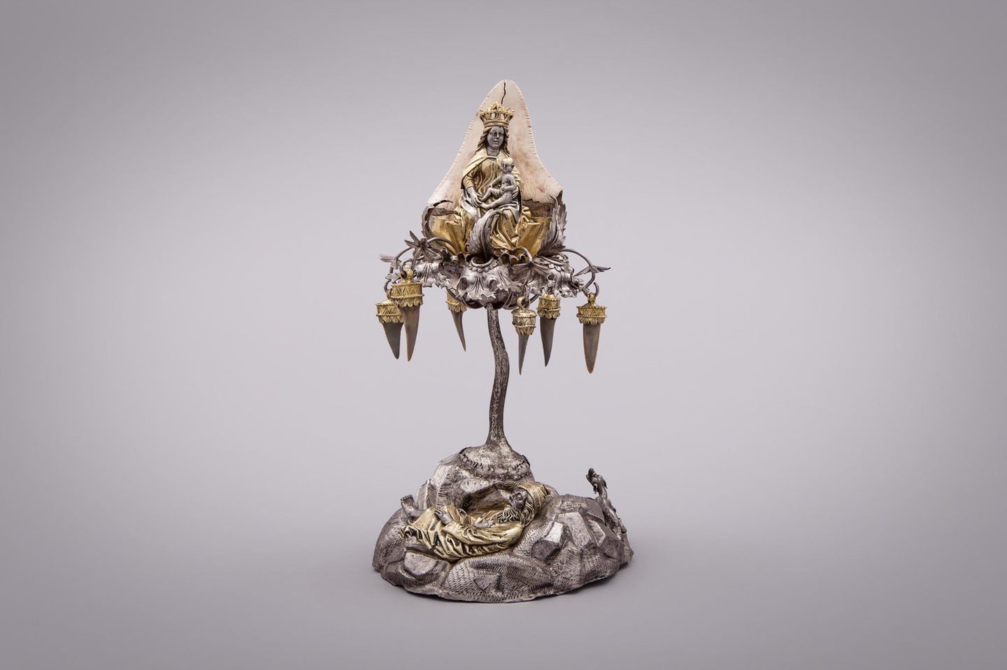 Baumartiges Gestell mit Marienfigur und Haifischzähnen