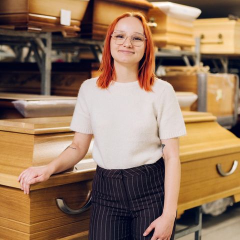 Werdende Bestattungsfachkraft Jocelyn Zschächer steht vor Särgen