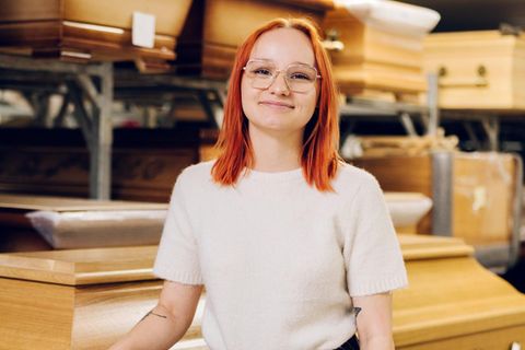 Werdende Bestattungsfachkraft Jocelyn Zschächer steht vor Särgen