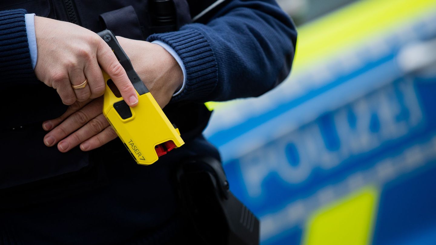 Ein Polizeibeamter demonstriert ein Distanz-Elektroimpulsgerät (DEIG), auch Taser genannt (Archivfoto) Foto: Rolf Vennenbernd/dp