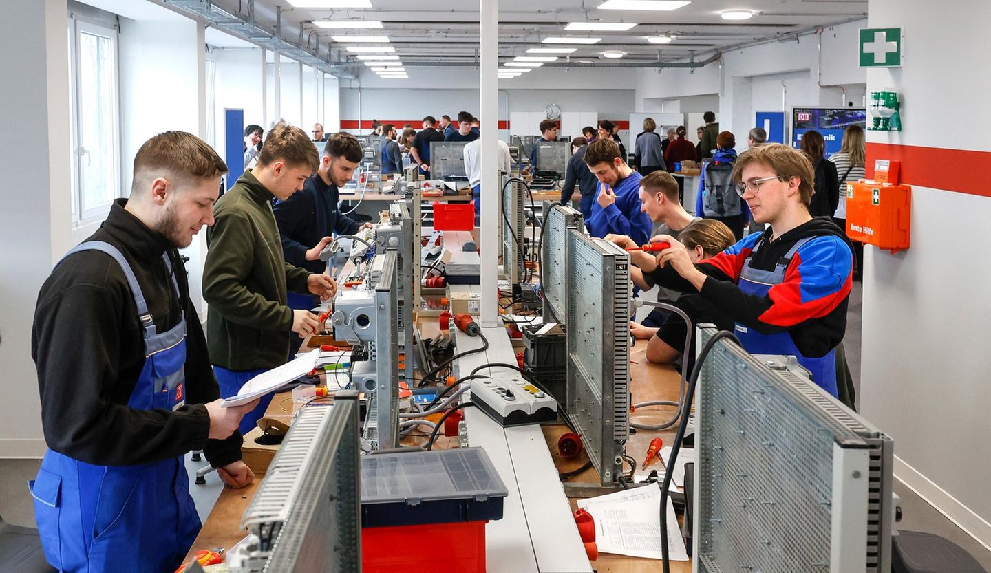 2. Gewerblich-technische Ausbildung Gewerblich technisch Auszubildende stehen in einer Reihe und hantieren mit Kabeln