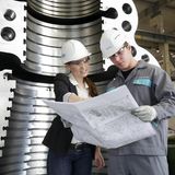 Zwei junge Ingenieure beugen sich über einen Bauplan