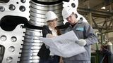 Zwei junge Ingenieure beugen sich über einen Bauplan