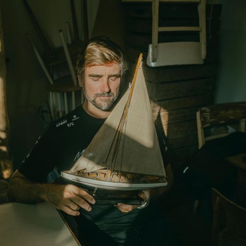 Segler Boris Herrmann hält ein Modellboot in der Hand