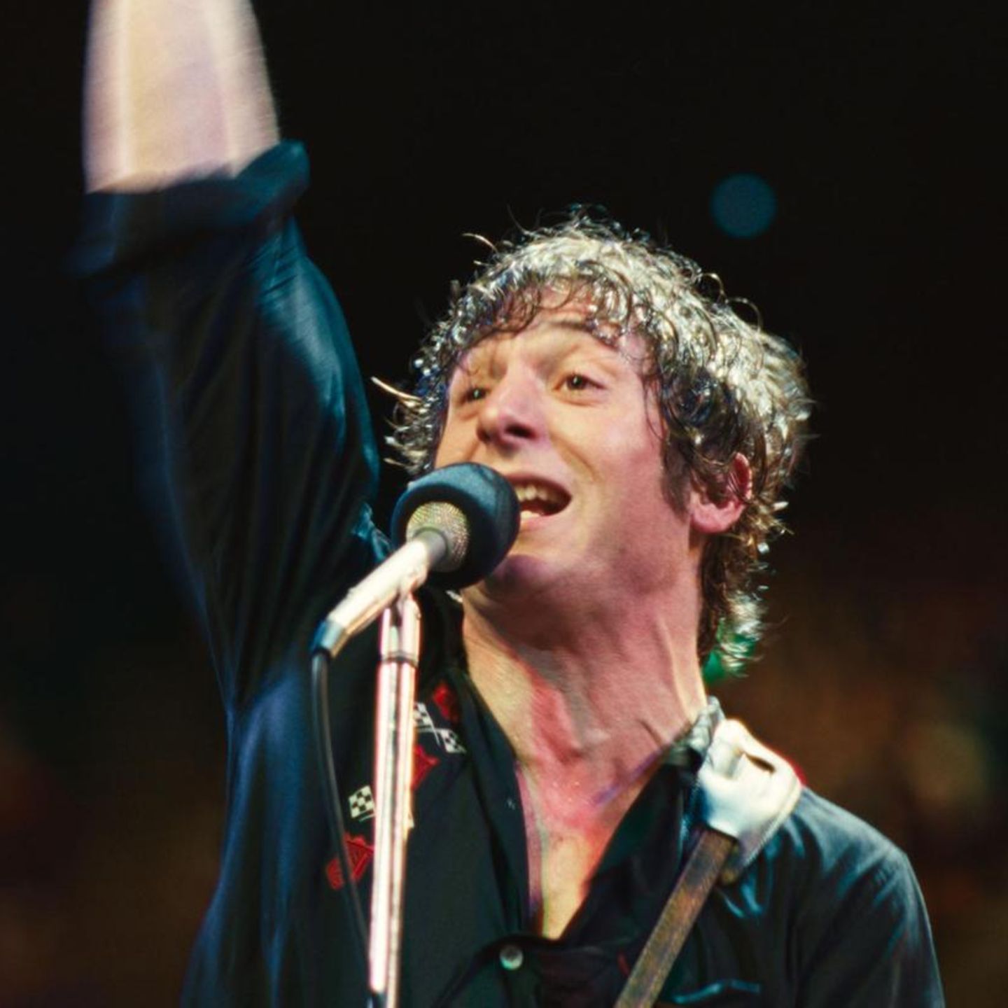 Bruce Springsteen alias Jeremy Allen White mit Mikrofon auf der Bühne