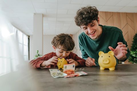 Ein Kind zählt Geld aus seinem Sparschwein