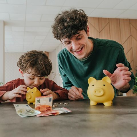 Ein Kind zählt Geld aus seinem Sparschwein