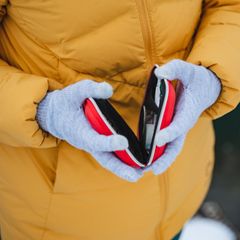 Deal News: Frau mit dicker Jacke und Handschuhen hält einen Handwärmer