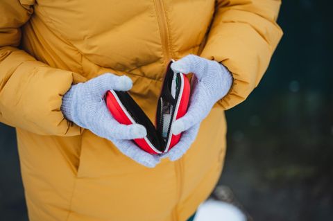 Deal News: Frau mit dicker Jacke und Handschuhen hält einen Handwärmer
