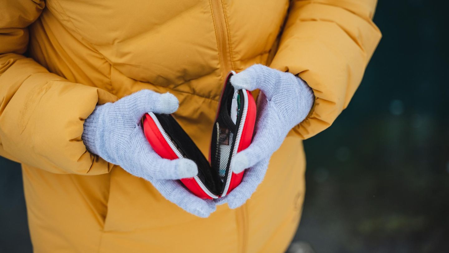 Deal News: Frau mit dicker Jacke und Handschuhen hält einen Handwärmer