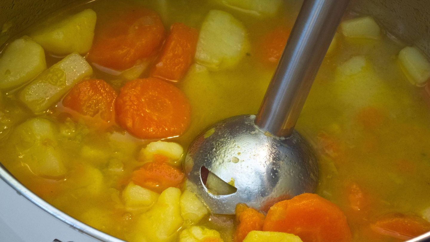 Ein Stabmixer in einem Topf mit Gemüse Ein Stabmixer in einem Topf mit Gemüse