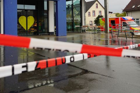 Die Polizei hat vor dem Supermarkt Absperrband angebracht, an der Seite steht ein Rettungswagen. Foto: Christian Müller/dpa