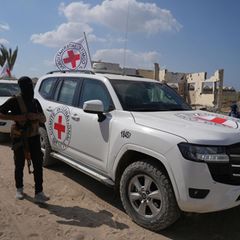 Autos des Roten Kreuzes neben Hamas-Soldaten