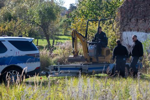 Polizisten untersuchen mit einem Bagger ein Grundstück in Herzberg (Landkreis Oder-Spree). Foto: Christophe Gateau/dpa