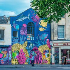 Banksy, wer sonst? Seit mehr als 30 Jahren prägt Streetart Bristol, angeregt von Graffiti-Kultur und dem bekanntesten Künstler der Stadt. In Stokes Croft finden sich Banksys frühe Werke wie "The Mild Mild West". Bei Festivals wie Upfest bemalen internationale Künstler ganze Straßen. Überall verwandeln sich Fassaden in Kunstwerke und machen die Stadt zur gelebten Galerie