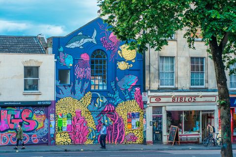 Banksy, wer sonst? Seit mehr als 30 Jahren prägt Streetart Bristol, angeregt von Graffiti-Kultur und dem bekanntesten Künstler der Stadt. In Stokes Croft finden sich Banksys frühe Werke wie "The Mild Mild West". Bei Festivals wie Upfest bemalen internationale Künstler ganze Straßen. Überall verwandeln sich Fassaden in Kunstwerke und machen die Stadt zur gelebten Galerie