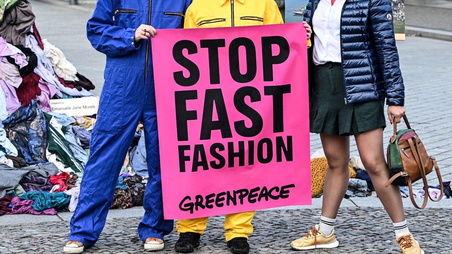 Die Umweltschützer wollen mit der Kunst-Aktion ein Zeichen gegen Müllberge aus Klamotten setzen, für die sie die Modeindustrie m