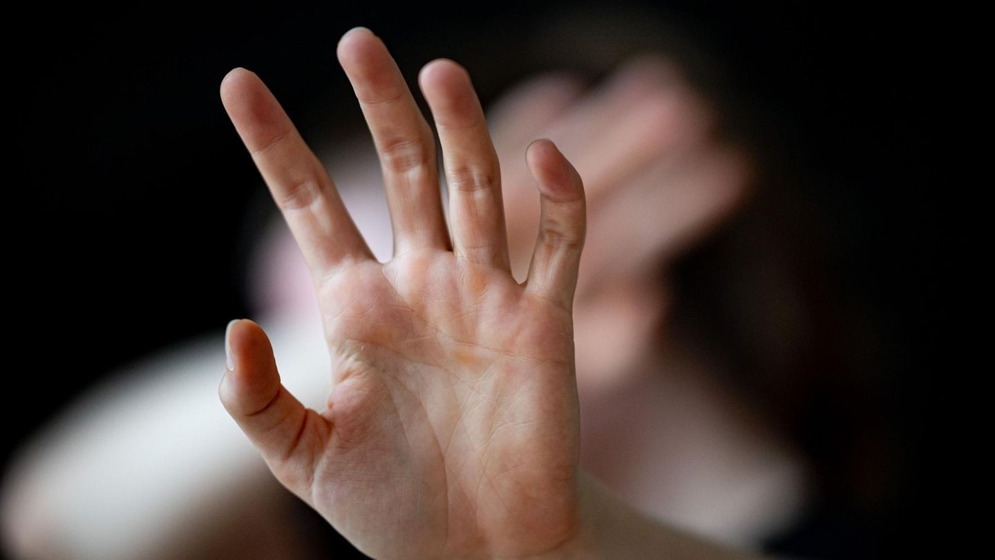 Eine Frau hält ihre Hände schützend vors Gesicht – Symbolbild Gewalt gegen Frauen