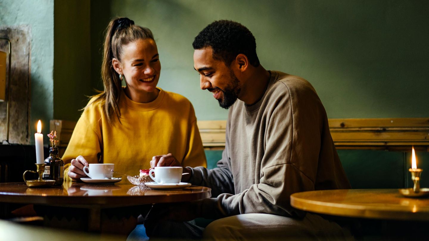 Eine Frau und ein Mann sitzen in einem Café (Symbolbild Affäre).