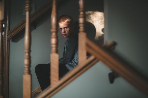 Handysucht: Kind sitzt traurig auf der Treppe