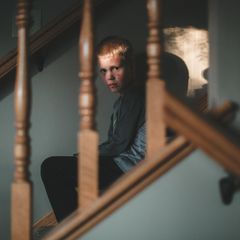 Handysucht: Kind sitzt traurig auf der Treppe