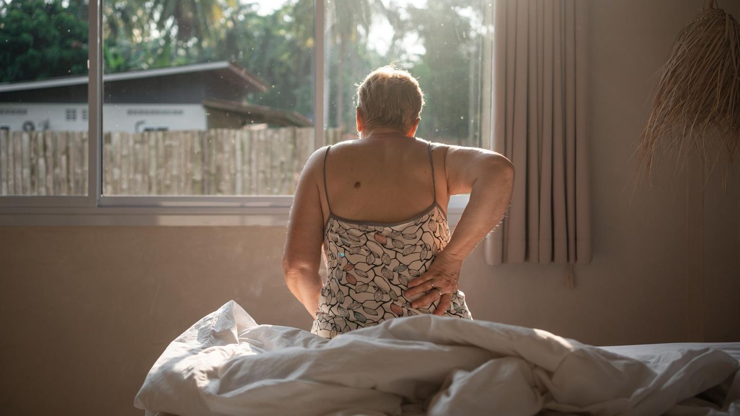 Eine ältere Frau hält sich den Rücken Eine ältere Frau hält sich den Rücken