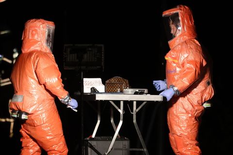 Feuerwehrleute untersuchen die Tasche mit dem undefinierten Stoff. Foto: David Young/dpa