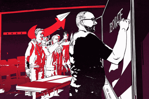 Der Lehrer schreibt "Demokratie" an die Tafel, während Schüler im Hintergrund den Hitlergruß zeigen