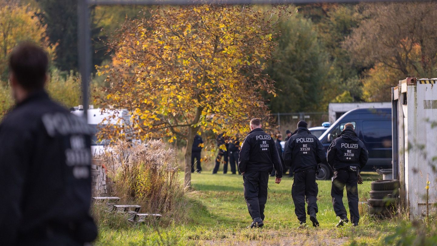 Polizisten stehen bei dem Großeinsatz auf einem Grundstück. (Archivbild) Foto: Christophe Gateau/dpa