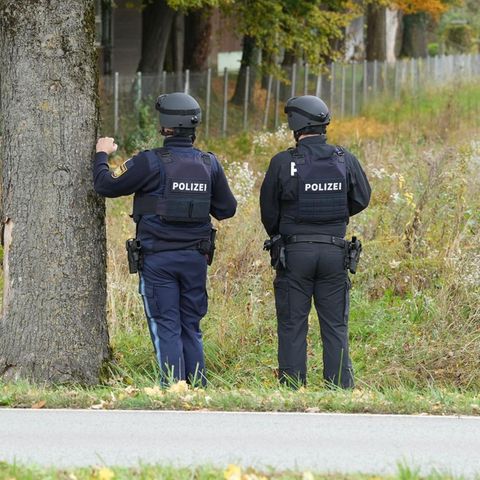 Erding: Zwei Polizisten stehen am Rande eines Feldes