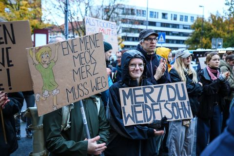 Ein Demonstrant hält ein Schild mit der Aufschrift "Merz, du Weidelsohn" hoch während einer Protestaktion nach den Aussagen von