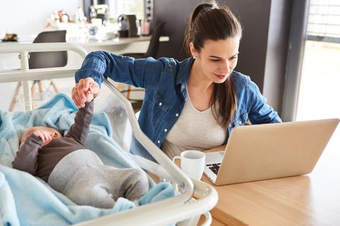 Mutter arbeitet mit Kind und erlebt Einkommensverlust