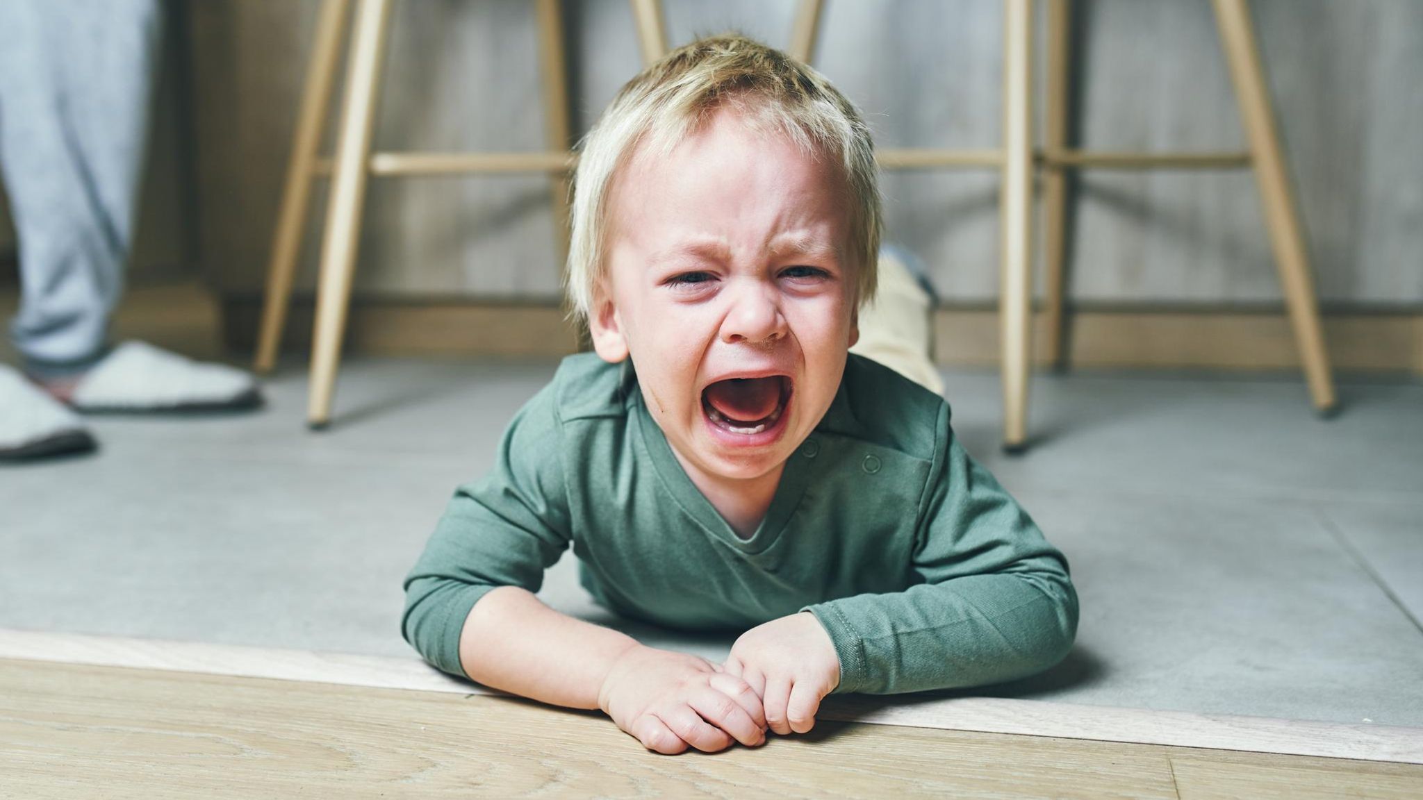 Ein Kita-Kind auf dem Boden, es weint und die Erzieherin ist weit und breit nicht zu sehen Ein Kita-Kind auf dem Boden, es weint und die Erzieherin ist weit und breit nicht zu sehen