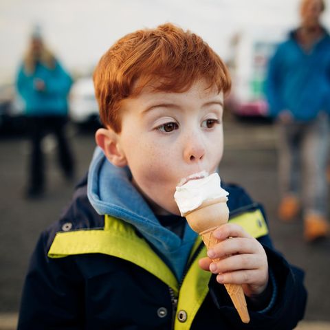 Ein Junge isst ein Eis in einer Waffel