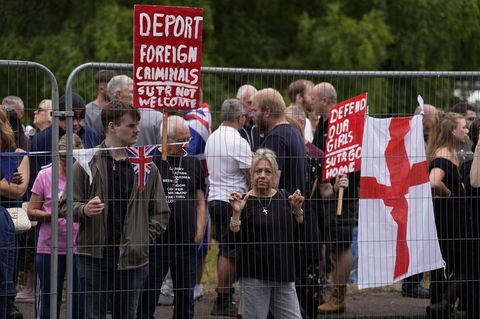 In Großbritannien protestierten Menschen vor einem ehemaligen Hotel, in dem mutmaßlich Asylbewerber untergebracht sind In Großbritannien protestierten Menschen vor einem ehemaligen Hotel, in dem mutmaßlich Asylbewerber untergebracht sind