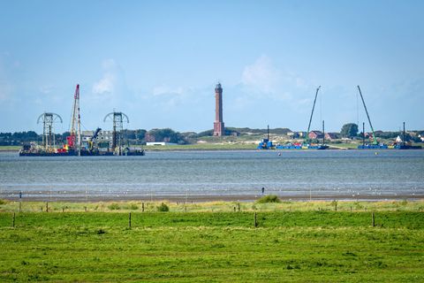 Vom Festland aus ist das Kabelverlegeschiff "Barbarossa" im Watt vor Norderney zu sehen. Foto: Sina Schuldt/dpa