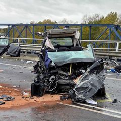 Ein völlig zerstörter schwarzer Pkw. Das Dach des Wagens ist größtenteils abgerissen