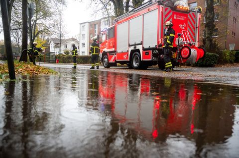 Regenwasser überschwemmt eine Straße in Hamburg-Lohbrügge, weil Herbstlaub die Gullys verstopft. Foto: Daniel Bockwoldt/dpa