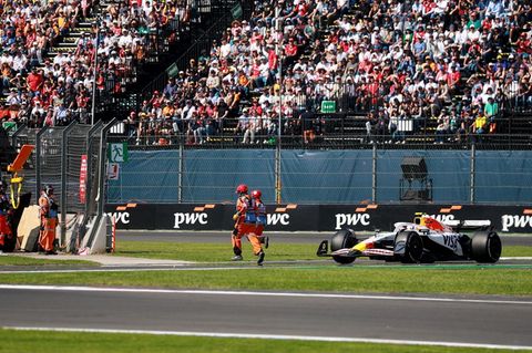 Streckenposten laufen beim Formel-1-Rennen in MExiko vor das Auto von Liam Lawson Streckenposten laufen beim Formel-1-Rennen in MExiko vor das Auto von Liam Lawson