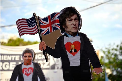 Demonstranten mit Plakaten von Milei und Trump