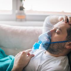 Deal News Inhalator Ein Mann liegt mit Inhalator auf dem Sofa