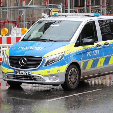 Ein Polizeifahrzeug parkt vor einer Einfahrt bei einer Razzia in Remscheid gegen organisierte Kriminalität