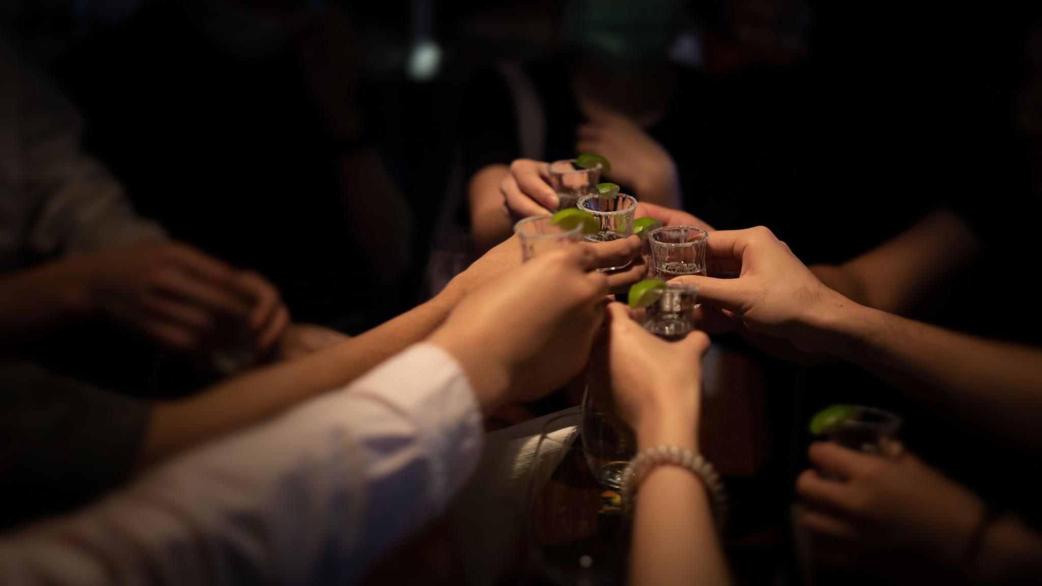 Menschen stoßen mit Tequila an