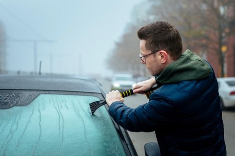 Eiskratzer Auto Man scraping snow off car windshield