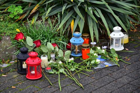Blumen und Kerzen wurden vor einem Wohnhaus in Solms abgelegt, in dem drei tote Menschen entdeckt wurden Blumen und Kerzen wurden vor einem Wohnhaus in Solms abgelegt, in dem drei tote Menschen entdeckt wurden