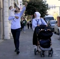 Traditionelle Familie und eine junge Frau in den Straßen der Türkei begegnen sich.