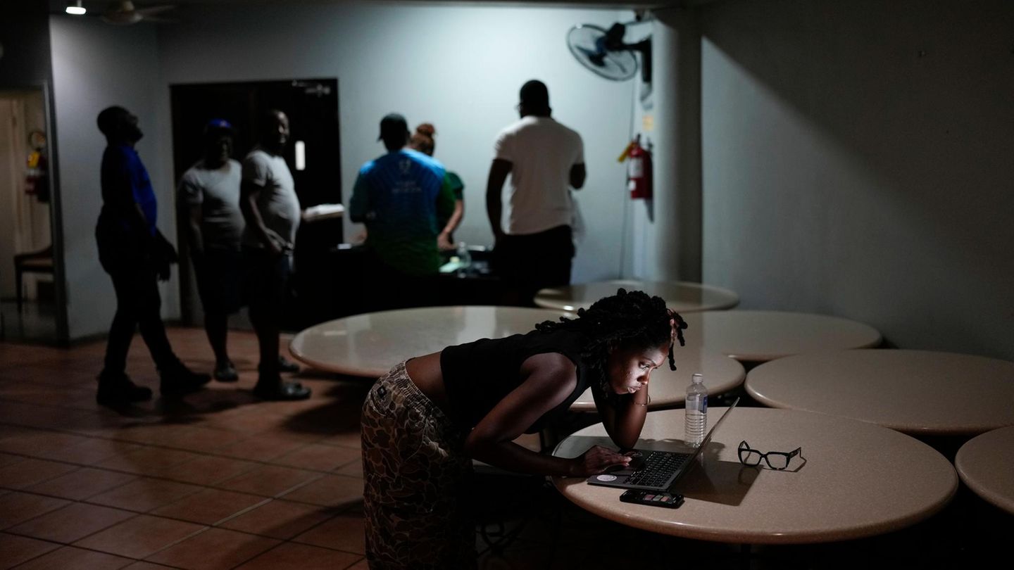 In vielen Orten von Jamaika ist mittlerweile der Strom ausgefallen. Hier nutzt eine junge Frau die Zeit, um noch einmal mit Freunden zu chatten