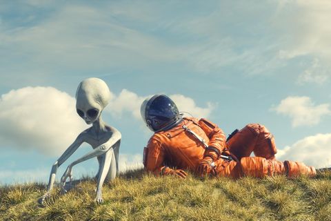 Alien und Astronaut auf einer Wiese