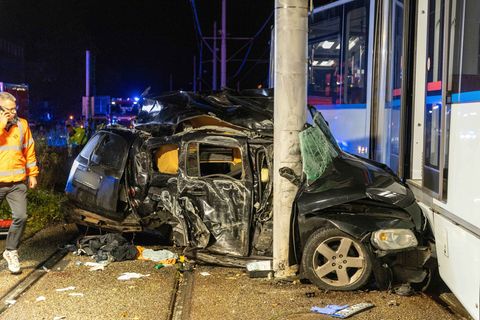 Das Auto wurde zwischen Betonmast und Straßenbahn eingeklemmt, die Aufräumarbeiten dauerten auch nachts noch an. Foto: Justin Br